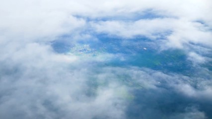 Wall Mural - 4K. traveling by air. view through an airplane window. airplane flight above clouds sky and countryside