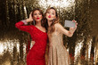 Portrait of two pretty young women in sparkly dresses