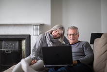 Senior couple at home using a laptop