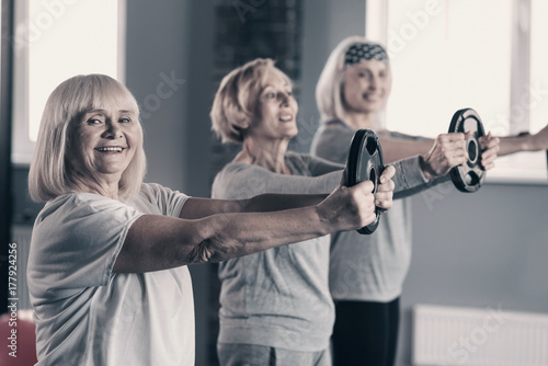 Plakat Starsze panie przeprowadzające trening dysku wagi