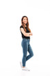 © Drobot Dean - Side view of young pretty chinese woman in black tshirt and jeans standing with crossed hands, looking at camera