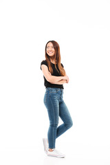 Sticker - Full length photo of young pretty chinese woman in black tshirt and jeans standing with crossed hands, looking aside