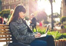 Woman Using Laptop Outdoor Sitting In The City Street, Urban Scene