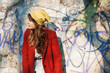 © vladteodor - Modern girl in autumn seasson, walking around the city in the beautiful sunset light over graffiti wall background.