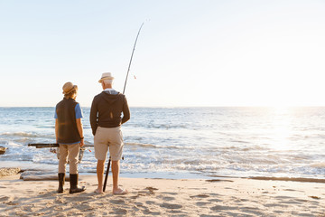 Wall Mural - Senior man fishing with his grandson