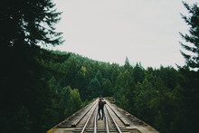 Young Man Stands On Train Trestle