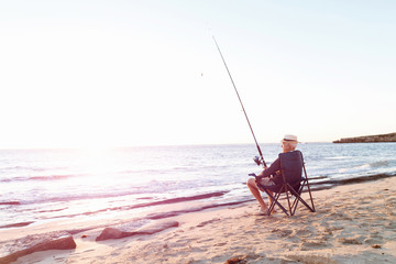 Wall Mural - Senior man fishing at sea side