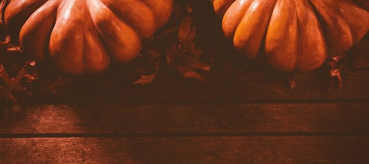 Wall Mural - Pumpkins with leaves on table during autumn