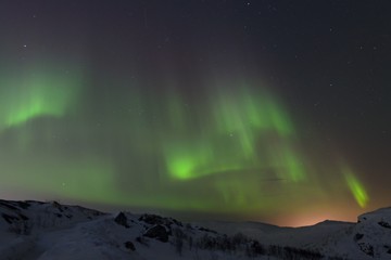 snow covered the hills and in the sky stars, clouds and northern lights.