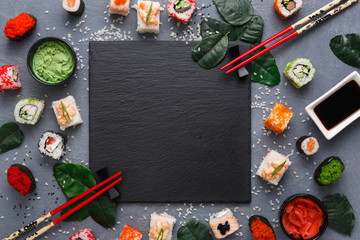 Wall Mural - Square black slate plate with sushi on rustic grey backround, copy space