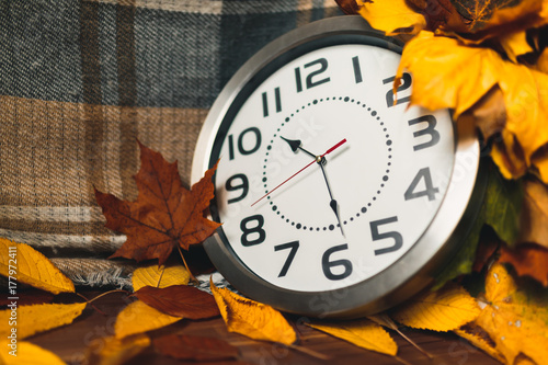 Zdjęcie XXL Jesienny czas. Zegar ścienny wśród kolorowych liści.