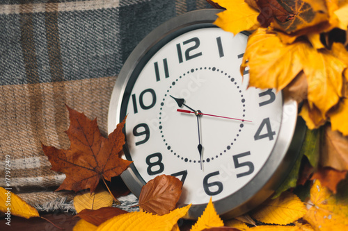 Zdjęcie XXL Jesienny czas. Zegar ścienny wśród kolorowych liści.