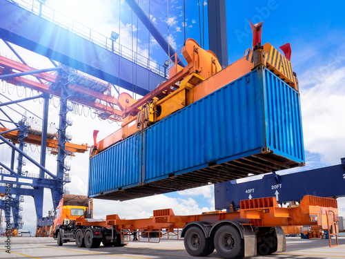 Vászonkép  Industrial port crane lift up loading export containers box onboard from truck at port of Thailand,The port crane type's twinlift is the best solution for port operations