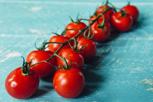 Red Tomatoes On A Light Blue Rough And Rustic Wooden Surface