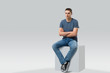 © Volodymyr Shcherbak - young man sitting on white cube. isolated