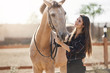 © Liubov Levytska - Young woman highly skilled equine foot care professional walking out a horse on animal farm on a sunny summer day.