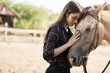 © Liubov Levytska - Portait of young female broodmare petting a new horse on a ranch on a sunny summer day.