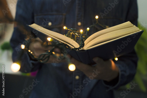 Zdjęcie XXL otwarta książka w rękach z bożonarodzeniowe światła