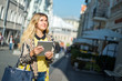 © dima - Young blond business woman using tablet computer walking in city street. Stylish fashion model in sunglasses