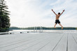 © Cara Slifka/Stocksy - Child jumps off a dock into a lake on a summer evening
