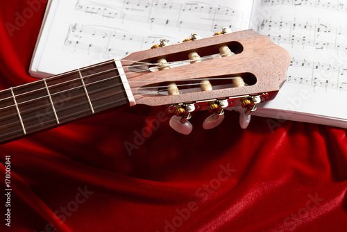 Plakat gitara akustyczna i nuty na czerwonym aksamicie tkaniny, Zamknij widok obiektów
