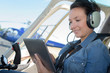 young woman helicopter pilot going through checklist before take off