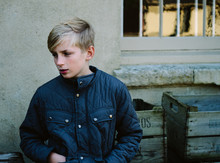 Pre-teen Boy In A Quilted Jacket Looking Away From Camera.