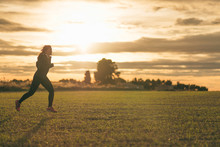 Young Woman Running In The Fields At Sunset