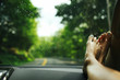 © Kelly Knox/Stocksy - woman's feet on the dashboard of a car during a road trip