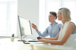 © pressmaster - Confident designer explaining colleague some curious moments of new program or app in the net