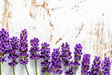 Fototapeta Lawenda - Frame with lavender flowers on white wooden background, overhead