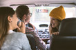 © BONNINSTUDIO/Stocksy - Three friends inside a car during a road trip.