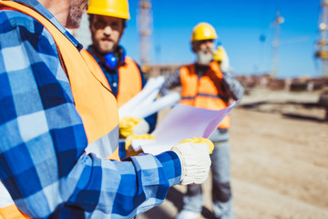 Wall Mural - Construction worker examining building plan