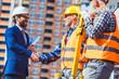 © LIGHTFIELD STUDIOS - Construction worker and businessman shaking hands