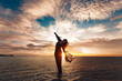 © zolotareva_elina - Elegant woman dancing on water. Sunset and silhouette.