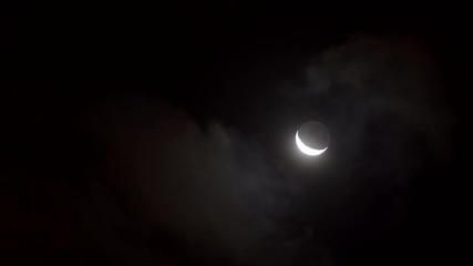 young moon mooving through clouds at night