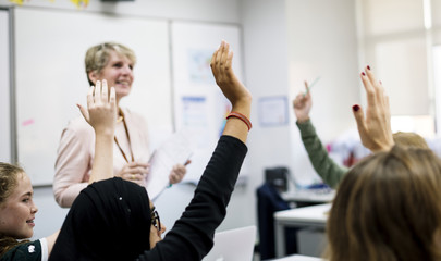 Wall Mural - students with their hands up responding to their teacher
