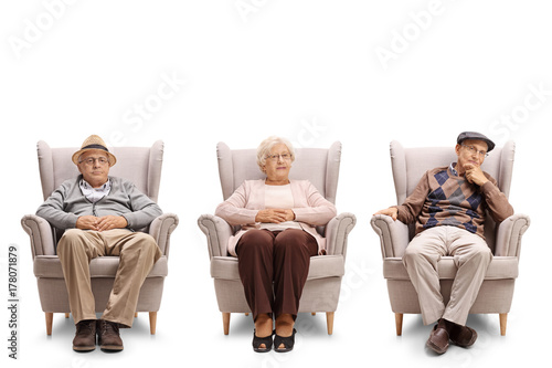 Plakat Seniorzy siedzi w fotelu i patrząc w kamerę