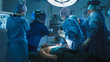 © Gorodenkoff - Medical Team Performing Defibrillation in Modern Operating Room. Everyone is looking on Cardiac Monitor.
