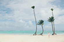 Woman Walking On Tropical Beach With Palm Trees