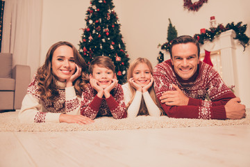 Poster - Four attrctive bonding relatives, at home, married couple of brunet and brunette haired, excited siblings, in knitted cute traditional x mas costumes, in socks, noel is here!