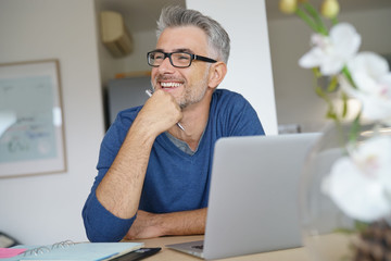 Middle-aged man working from home-office on laptop