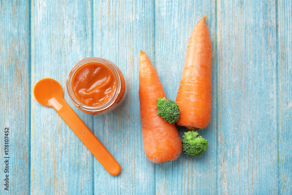 Jar with baby food on wooden table