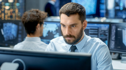Fototapete - Neural Network and Machine Learning Engineer Programming at His Workstation. Office is Crowded With People Working. Multiple Displays Show Neural Network, Artificial Intelligence Representation.