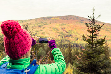 Sticker - Hiking woman with backpack taking photo with smartphone