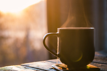 Still life with cup of coffee on the carpathian mountains background during the sunset