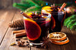 © nesavinov - Two glasses of christmas mulled wine with oranges and spices on wooden background.