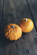 Two Pumpkins At Wooden Table