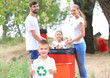 © Africa Studio - Family throwing garbage into litter bin outdoors. Recycling concept