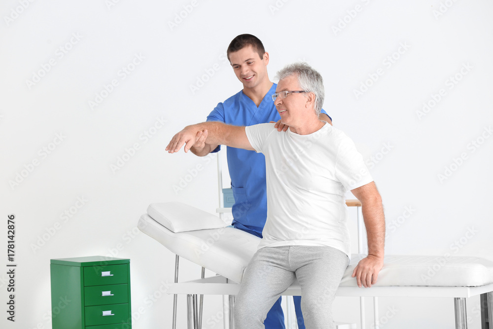 Physiotherapist working with senior patient in modern clinic